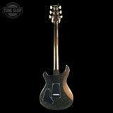 A dark glitter-finish electric guitar shown from the back against a solid black background, with a Tone Shop watermark in the upper left corner.