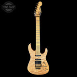 Electric guitar with a distinctive design on a black background, featuring the Tone Shop logo.