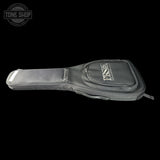 A black guitar or bass instrument gig bag with a silver-toned metal logo plate reading 'TONE SHOP' on the front pocket, shown against a solid black background.