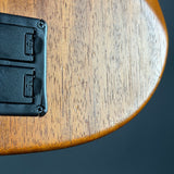 Close-up of a wooden surface with a black plastic component.
