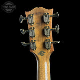 Close-up of the headstock of a guitar, showing six tuning pegs with 'TONE SHOP' branding and a natural wood grain finish against a black background.