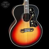 A close-up of a sunburst acoustic guitar body with a black pickguard featuring gold and white floral inlay, set against a solid black background with a Tone Shop watermark in the top left.