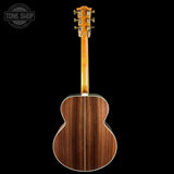 The back of an acoustic guitar with a rich dark brown wood grain finish, shown against a solid black background with a Tone Shop watermark in the top left corner.