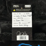 A close-up of a black plush or faux-fur surface with a hanging PRS Studio guitars retail tag. The tag shows product details including model 'Gustav 24 Anuki Sewikella GTR', neck 'Pattern Tun', and a signature near the barcode.
