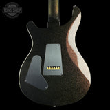 The back of an electric guitar with a black glitter finish, a silver pickguard, and a white gloss accent strip, shown against a black background with a Tone Shop watermark in the top left.
