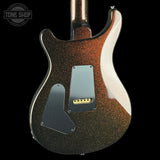The back of an electric guitar with a dark brown and black glitter finish, featuring a silver pickguard and a gold bridge, shown against a black background with a Tone Shop watermark in the top left.