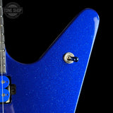 Close-up of a blue glitter electric guitar body with a silver toggle switch and part of the neck visible against a black background.