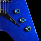 Close-up of a blue glitter electric guitar body with three black and blue control knobs, a black pickguard engraved with '2026', and part of the silver strings against a black background.