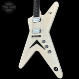 An electric guitar with a distinctive angular V-shaped body in a matte off-white finish, featuring black hardware, dual humbucker pickups, and a black pickguard, shown against a solid black background.