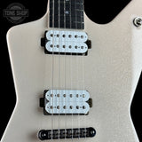 Close-up of a silver glitter electric guitar body with two white humbucker pickups, black hardware, and a black fretboard against a black background. A Tone Shop watermark is visible in the top-left corner.