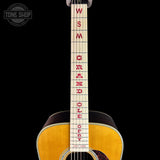 Close-up of the neck of an acoustic guitar against a black background, featuring red lettering on the fretboard that reads 'WSM GRAND OPEFFY'. A Tone Shop watermark is visible in the top-left corner.