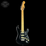 A black Fender Stratocaster electric guitar with a natural maple neck and headstock, shown against a solid black background. A 'Tone Shop' watermark is visible in the top-left corner.