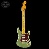 Green electric guitar with a black background