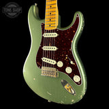 Green electric guitar with a worn finish on a black background, featuring the Tone Shop logo.