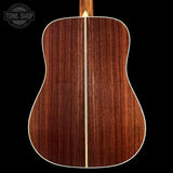 Back view of a wooden acoustic guitar with 'Tone Shop' logo in the corner.