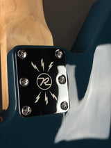Close-up of a guitar pickup with a brand logo on a dark background