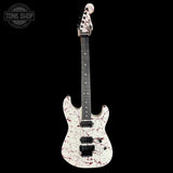 White electric guitar with red splatter design on a black background, featuring 'Tone Shop' logo.