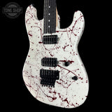 Electric guitar with a white body and red splatter design on a black background, featuring the 'Tone Shop' logo.