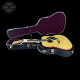 Acoustic guitar in an open case with 'Tone Shop' branding.