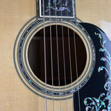 Close-up of an acoustic guitar's soundhole and decorative binding.