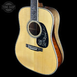 Acoustic guitar with a visible brand logo on a black background