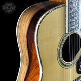 Close-up of an acoustic guitar with a visible brand logo in the corner.