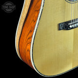 Close-up of an acoustic guitar with a visible brand logo in the corner.
