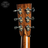 Close-up of a guitar headstock with tuning pegs on a black background, featuring the Tone Shop logo.