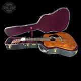 Acoustic guitar in an open case with 'Tone Shop' branding.