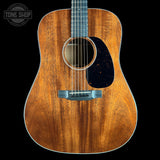 Acoustic guitar with a visible brand logo on a black background