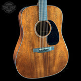 Acoustic guitar with a visible brand logo on a black background