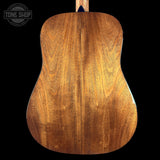 Back view of a wooden acoustic guitar with 'Tone Shop' logo.
