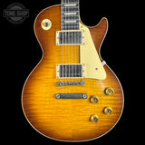 Electric guitar with a sunburst finish on a black background, featuring the Tone Shop logo.