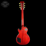 Red electric guitar with a black background, featuring the Tone Shop logo.