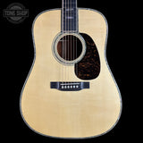 Acoustic guitar with a visible brand logo on a black background