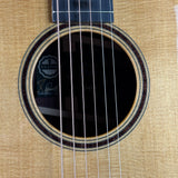 Close-up of a Taylor acoustic guitar's soundhole and brand logo.