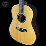Acoustic guitar with a visible brand logo on a black background