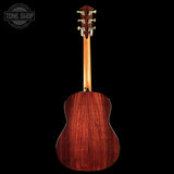 Back view of a wooden acoustic guitar on a black background with 'Tone Shop' logo.