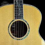 Close-up of an acoustic guitar with a visible brand logo on a black background