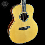 Acoustic guitar with a visible brand logo on a black background