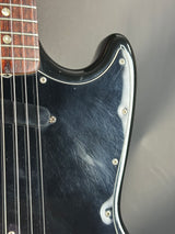 Close-up of a guitar's headstock and neck with a blurred background