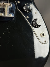 Close-up of a guitar's control knobs and headstock.