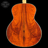 Close-up of a wooden acoustic guitar back with 'Tone Shop' logo.