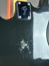 Close-up of a guitar with a visible brand logo on a black finish