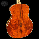 Close-up of a wooden acoustic guitar back with 'Tone Shop' logo.