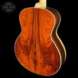 Close-up of a wooden acoustic guitar body with 'Tone Shop' branding.