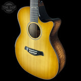 Acoustic guitar with a visible brand logo on a black background
