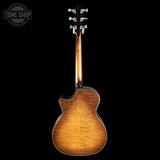 Back view of a brown acoustic guitar on a black background with 'Tone Shop' logo.