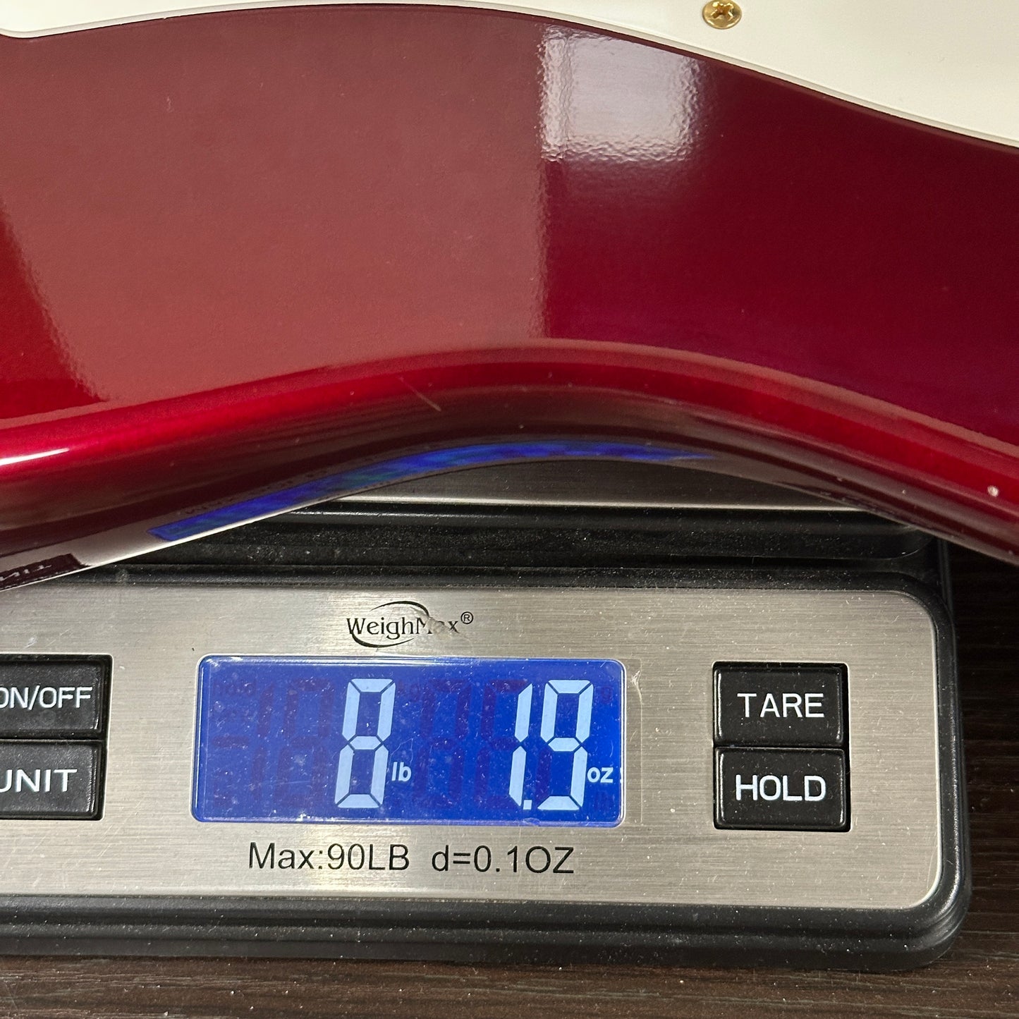 Digital scale displaying weight with a red object on top