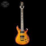 Electric guitar with a sunburst finish on a black background, featuring the Tone Shop logo.